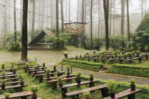 Foto sebuah bangunan kafe/tempat wisata modern dengan kubah kaca futuristik di perbukitan Lembang saat senja (golden hour)
